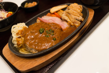 pork bacon on black pan and wood tray with sauce