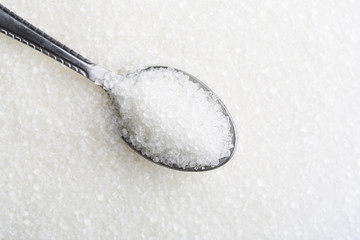 Fototapeta na wymiar Closeup of spoon with white sugar