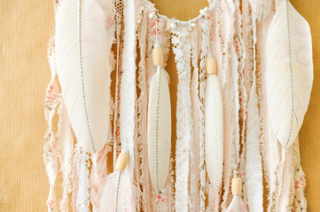 Closeup details handmade dreamcatcher with painted feathers on craft paper background