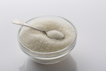 A glass bowl of sugar with spoon