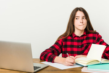 Young teenager going back to her routine doing homeworks confused, feels doubtful and unsure.