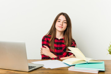 Young teenager going back to her routine doing homeworks who feels confident, crossing arms with determination.