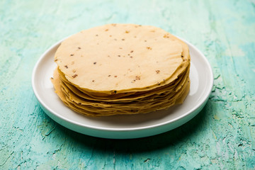Gujarati papad or papadum in raw dried form with roasted cone, roll and flat variation