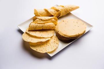 Gujarati papad or papadum in raw dried form with roasted cone, roll and flat variation