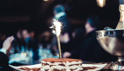 Candela su torta di compleanno in locale 