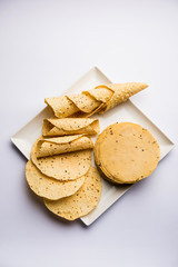 Gujarati papad or papadum in raw dried form with roasted cone, roll and flat variation