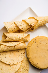 Gujarati papad or papadum in raw dried form with roasted cone, roll and flat variation