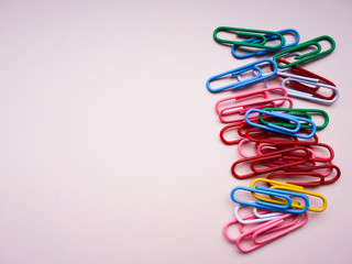 multicolored paper clips on a pink background. The concept is time to school.