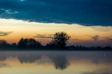 Naklejka na ściany i meble Fog over the lake and cloud in the sky