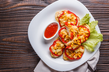 Chicken fillet in a batter with corn, paprika, lettuce and spicy tomato sauce on white plate