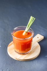 Fresh Carrot Juice in a Glass on a Dark Grey Background Healthy Drink Detox Diet Juice Glass of Tasty Carrot Juice on Wooden Board Vertical