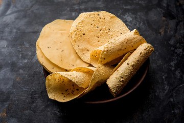 Gujarati papad or papadum in raw dried form with roasted cone, roll and flat variation