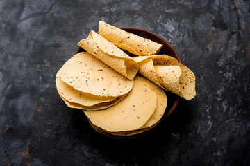 Gujarati papad or papadum in raw dried form with roasted cone, roll and flat variation