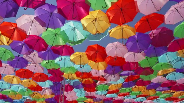 Top view of street decorated with multicolored umbrellas in Aix en Provence, France. Beautiful colorful parasols hanging in air above at sunny summer day
