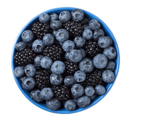 Bowl full of fresh blackberries and blueberries on white background.