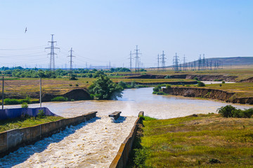 Small dam with water flowing rapids. Seen lines and patterns with foam.