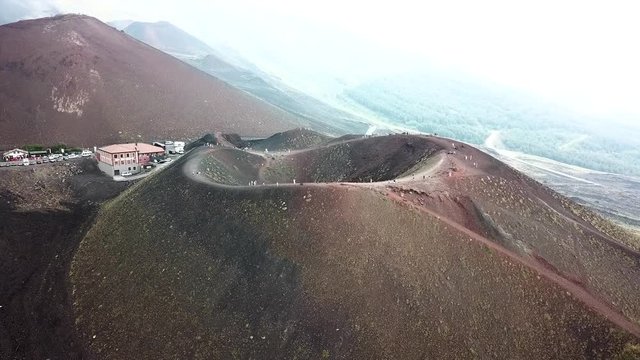 Aerial drone going slowly towards the crater of the Etna vulcano near Catania in Sicily, Italy, and slightly panning left.
