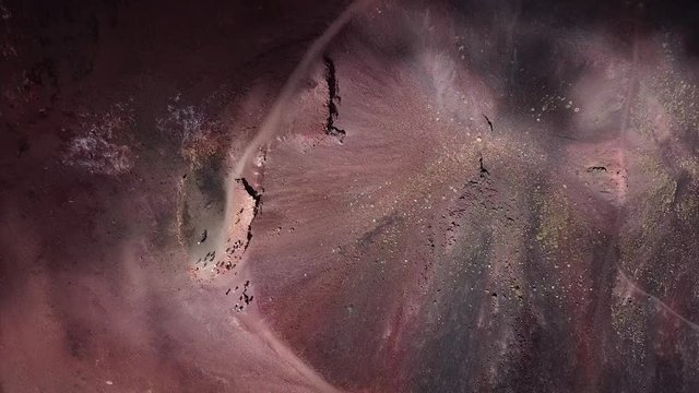 Aerial drone shot tilted down towards the crater of the Etna vulcano near Catania in Sicily, Italy.