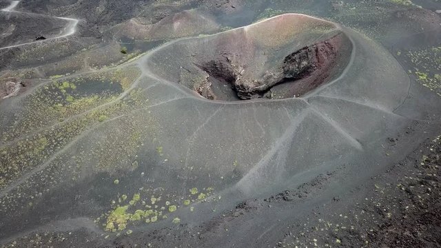 Aerial drone going slowly towards the crater of the Etna vulcano near Catania in Sicily, Italy, and slightly panning left.