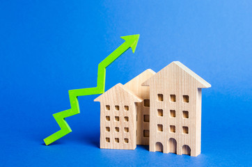 figures of residential buildings and green arrow up. Rising value and price. Apartments for sale....