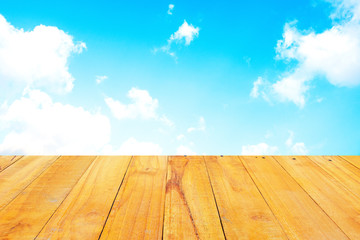 Old Wooden table with blue sky white cloud background.