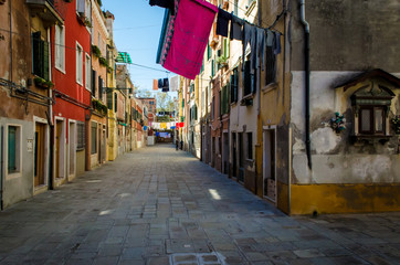 Fototapeta na wymiar Bucato steso ad asciugare in una calle di Venezia con un tabernacolo dedicato a Sant'Antonio