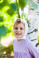 Girl   in  white handkerchief  near   birch
