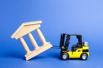 Yellow forklift overturns a government building. Bank, museum, monument of architecture....