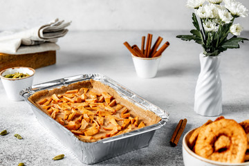 Healthy raw vegan tart with oatmeal base and dried apple stuffing, sprinkled with cinnamon, selective focus