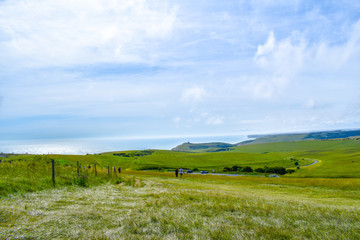 Fototapeta na wymiar Seven Sisters National Park landscape with green fields and blue ocean in Sussex, UK