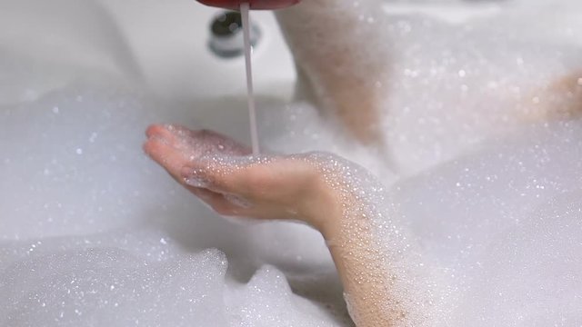 Female pouring shower gel and applying it, organic bodycare, skin nutrition