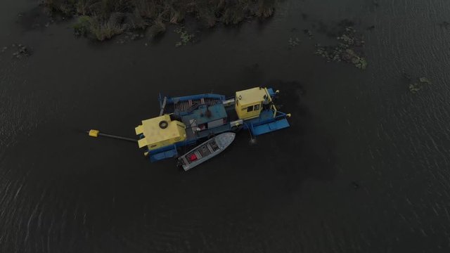 Aerial view excavator and heavy equipment, dredging and deepening channel mountain river. Heavy dredging machine on a river bank. Excavator dredge a river.