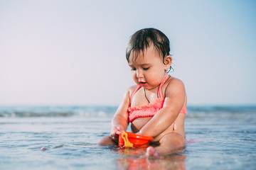 charming girl sitting in the sea with the wind