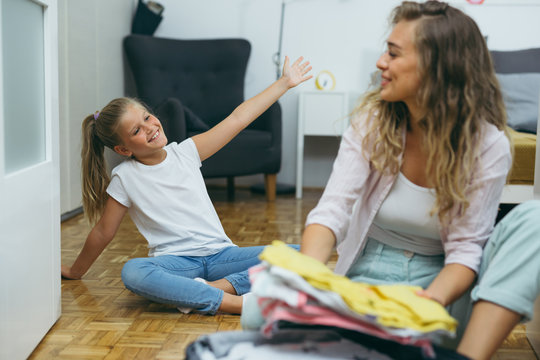 mother and daughter packing suitcase for vacation