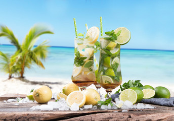 Mohito lime drinks on wooden with blur beach background
