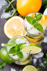 Mohito lime and orange drinks on black background