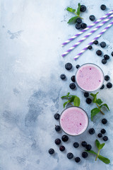 Fototapeta na wymiar Fresh healthy blueberries smoothie berries and mint in glass on light white concrete background. Top view. Copy space.