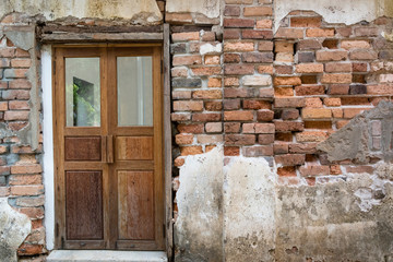 detail of ancient brick wall. Grunge Distorted Brick wall. old brick wall texture. Texture background surface broken brick wall and door.