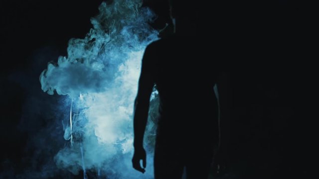 The woman and man walking in the smoke cloud. night time, slow motion