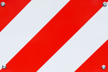 Red and white striped metal road barrier close up texture