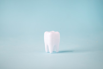 Dental care concept, Healthy tooth model on blue background with copy space. Minimal dentistry, oral tooth hygiene concept
