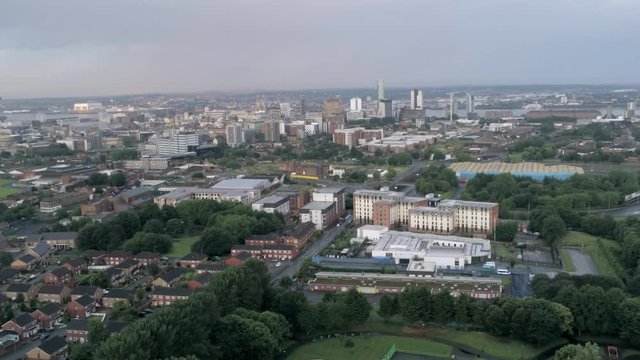 Aerial cityscape across Liverpool city buildings, cathedral, radio city tower along skyline. Wide orbit left.