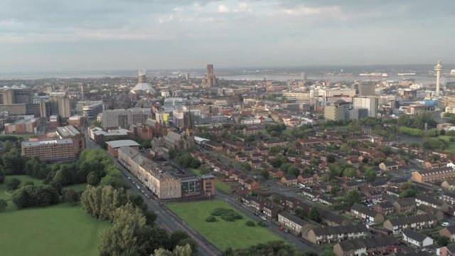 Aerial cityscape across Liverpool city buildings, cathedral, radio city tower along skyline. Pull back dolly right.