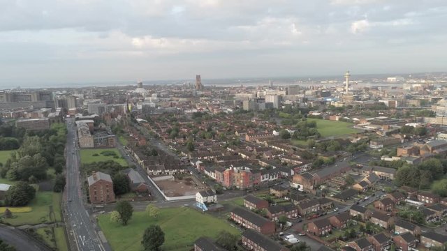 Aerial cityscape across Liverpool city buildings, cathedral, radio city tower along skyline. Dolly left.