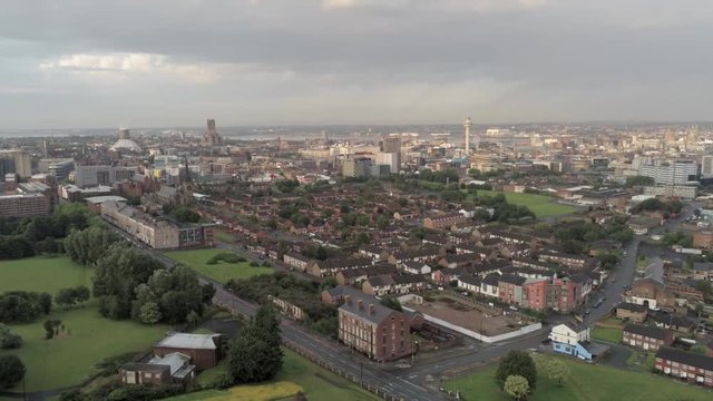Aerial cityscape across Liverpool city buildings, cathedral, radio city tower along skyline. Slow pull back.