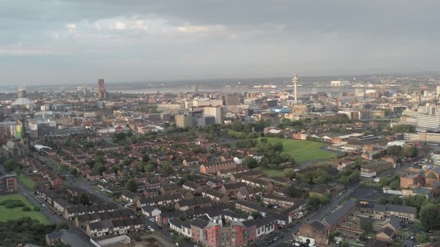 Aerial cityscape across Liverpool city buildings, cathedral, radio city tower along skyline. Dolly left.