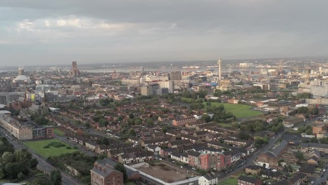 Aerial cityscape across Liverpool city buildings, cathedral, radio city tower along skyline. Right dolly.