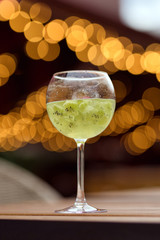Close-up glass with green summer cocktail and beautiful bokeh