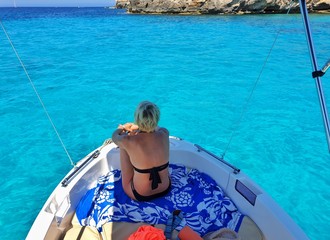 Une jeune femme blonde assise &agrave; la proue d'un bateau