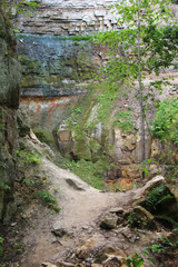 High stone wall in canyon and forest trees